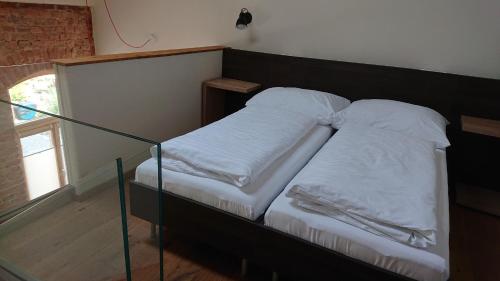 a bed with two pillows on it in a room at Maison am Liesingbach in Vienna