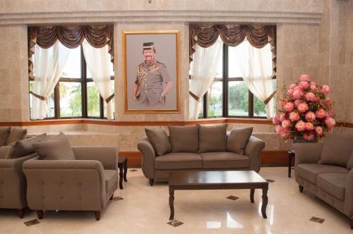 a living room with couches and a painting of a soldier at Mulia Hotel in Bandar Seri Begawan