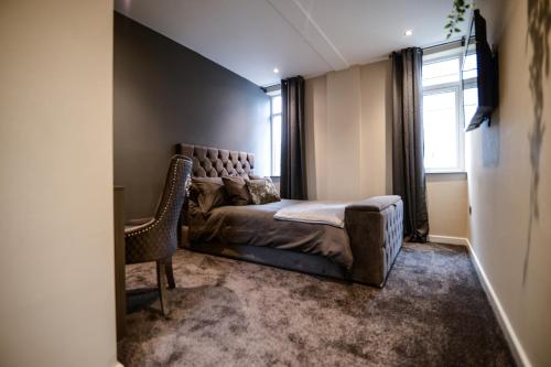 ein Schlafzimmer mit einem Bett, einem Stuhl und einem Fenster in der Unterkunft Ladywell House Suites - Chinatown - Self Check-in in Birmingham