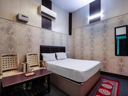 a small bedroom with a bed and a table at Nattha By Indian Culture in Lucknow