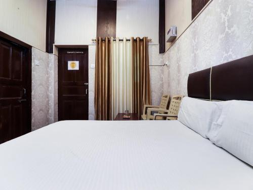 a bedroom with a large white bed and a chair at Nattha By Indian Culture in Lucknow