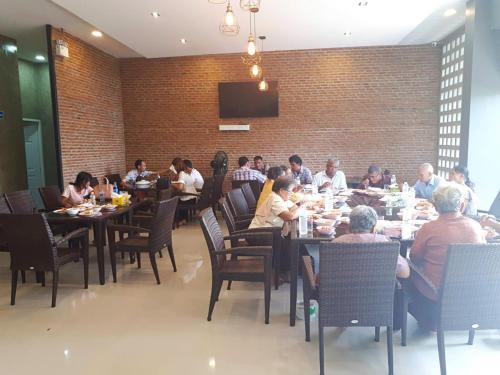 a group of people sitting at tables in a restaurant at Sawasdee​ Buriram​ Resort in Buriram