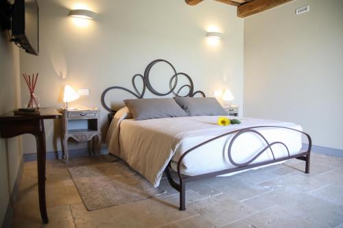 a bedroom with a bed and a table with a night stand at Villa Angela Country House in Fermo
