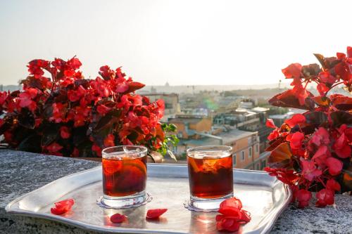 two glasses of tea on a tray with roses at Bettoja Hotel Mediterraneo in Rome