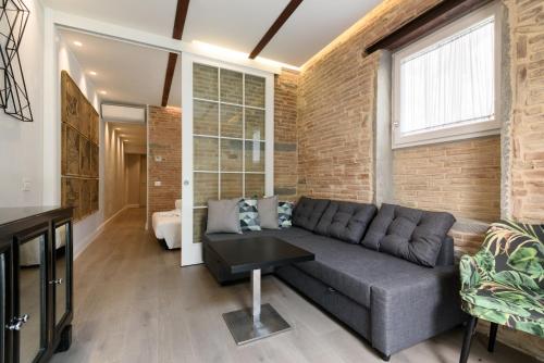 a living room with a couch and a brick wall at Vivaldi luxury suites in Florence