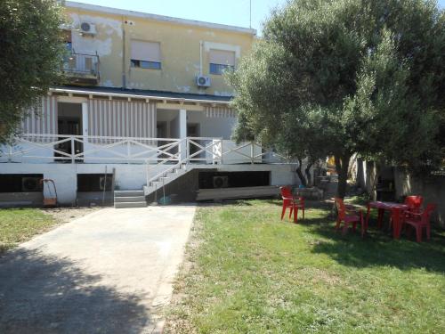 a building with red chairs and tables in the yard at La Rosa dei Venti in Teulada