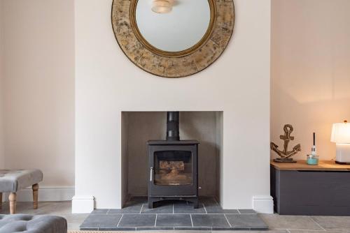 a living room with a fireplace and a mirror at The Old Chequers - Hot tub & Games room in Fakenham