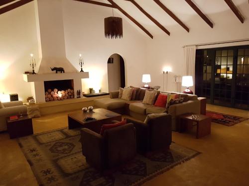 a living room with a couch and a fireplace at Kili Villa Kilimanjaro Luxury Retreat in Arusha