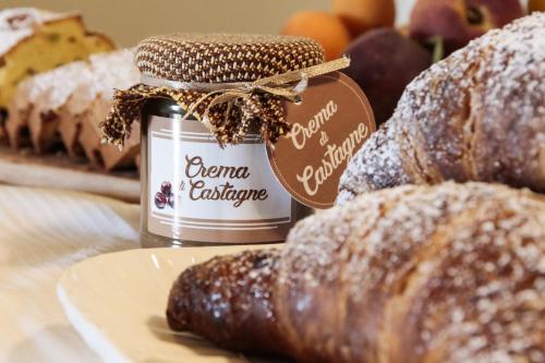 a jar of jam and some pastries on a plate at Villa Angela Country House in Fermo