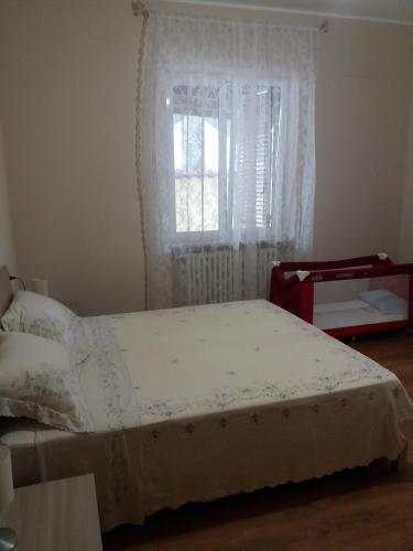 a bedroom with a white bed with a window at La casa di Giò in Montesilvano