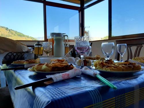 ベラトにあるGuest House Pashollariのテーブル(食べ物、ワイングラス付)