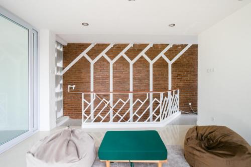 a living room with a brick wall and a green ottoman at RedDoorz near Universitas Islam Indonesia in Yogyakarta