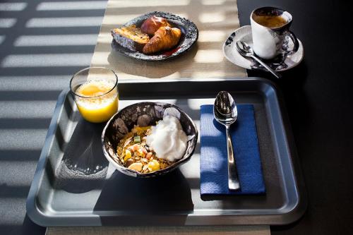 a tray with a bowl of food and a glass of orange juice at Nautilus Lanzarote in Puerto del Carmen