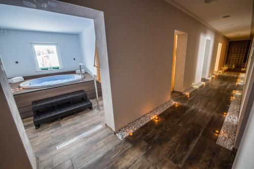 a large bathroom with a tub and a wooden floor at Hotel Granit Smrekovica in Liptovská Osada
