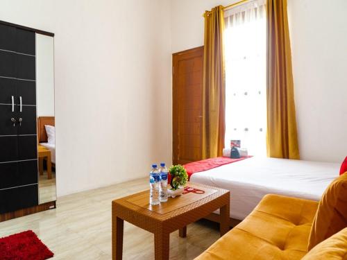 a living room with a bed and a table at RedDoorz near Cipinang Indah Mall in Jakarta