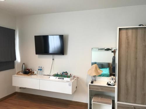a living room with a tv on the wall at Autta house in Ban Lat Tanot