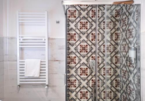 y baño con ducha y pared de azulejos. en Calenda Suite, en Nápoles