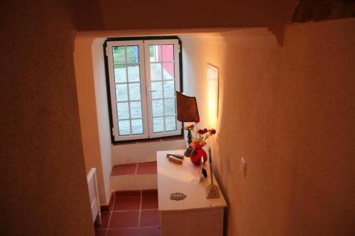 a room with a table with a lamp and a window at Casa Do Salgueiral in Fundão