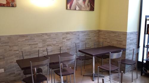 a dining room with tables and chairs and a clock on the wall at Hostel Mosaic in Rome