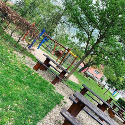 a park with benches and a playground with a slide at Penzion & Restaurace U Vily in Sezimovo Ústí