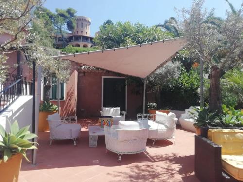 a patio with white chairs and a canopy at Residenza Villa Spagnola in Parghelia