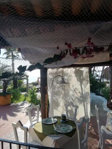 a table and chairs on a porch with a tent at Residenza Villa Spagnola in Parghelia