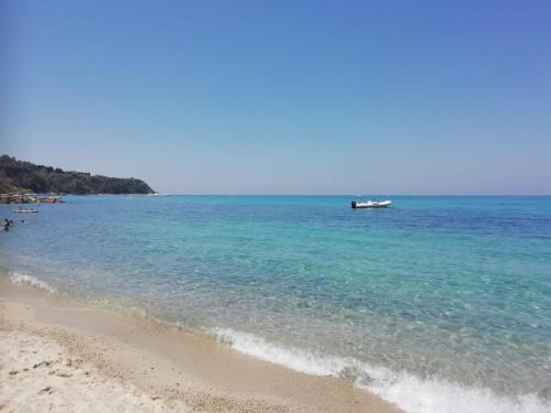a beach with a boat in the water at Residenza Villa Spagnola in Parghelia