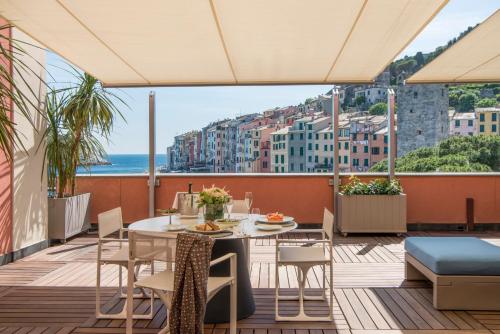 a balcony with a table and chairs and a view of the city at Grand Hotel Portovenere in Portovenere