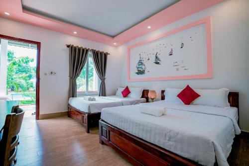 une chambre avec deux lits et une grande fenêtre dans l'établissement Long Mountain Resort, à Duong Dong