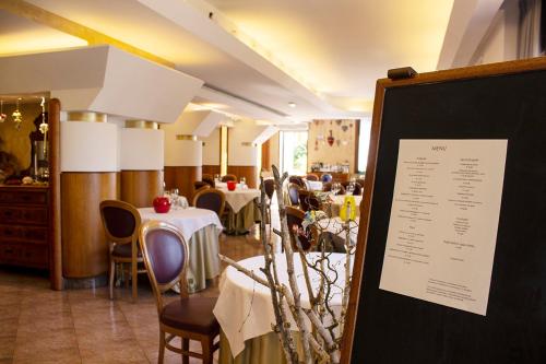 a restaurant with tables and chairs and a menu at Albergo Ristorante Belvedere in Codroipo
