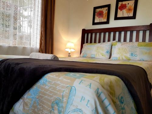 a bedroom with a large bed with a bedspread at Chinyonga Guesthouse in Limbe