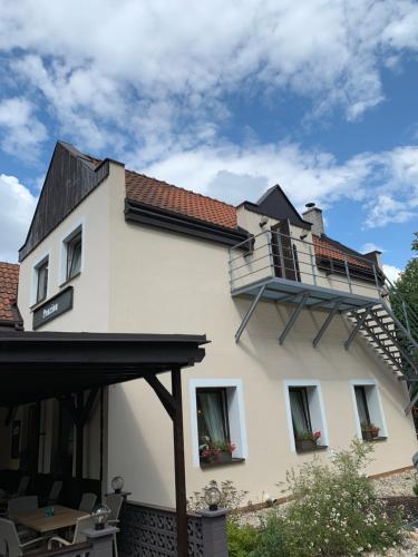 a house with a balcony on the side of it at Penzion & Restaurace U Vily in Sezimovo Ústí