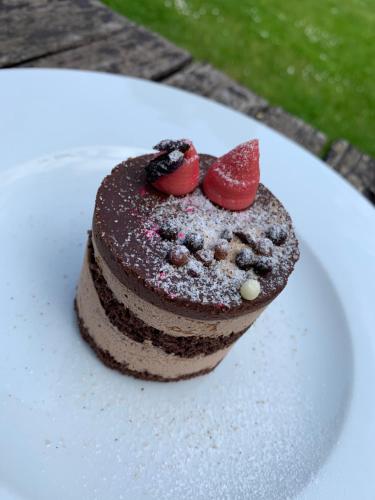 a chocolate cake with strawberries on a white plate at Penzion & Restaurace U Vily in Sezimovo Ústí