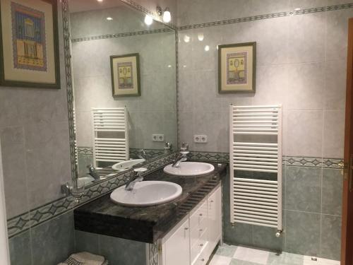 uma casa de banho com 2 lavatórios e um espelho grande em VIVIENDA DE USO TURÍSTICO CENTRO em Ávila
