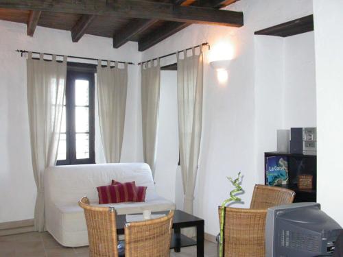 un salon avec un canapé blanc et une télévision dans l'établissement Sole e Ventu (70 qm), à San-Giovanni-di-Moriani