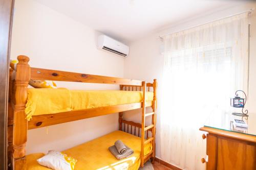 two bunk beds in a room with a window at Cubo's Finca el Cortijito de Herrera in Alhaurín el Grande