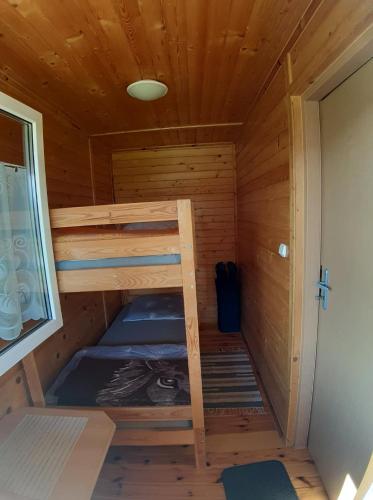a wooden cabin with two bunk beds in it at Domek Irenka in Puck