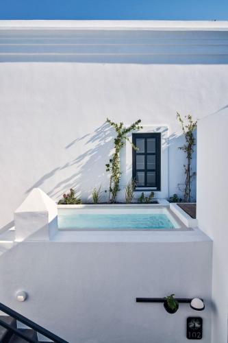 a swimming pool in a white house with a window at Katikies Garden Santorini - The Leading Hotels Of The World in Fira