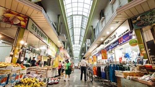 a group of people walking through a market at Appletree Guesthouse in Seoul
