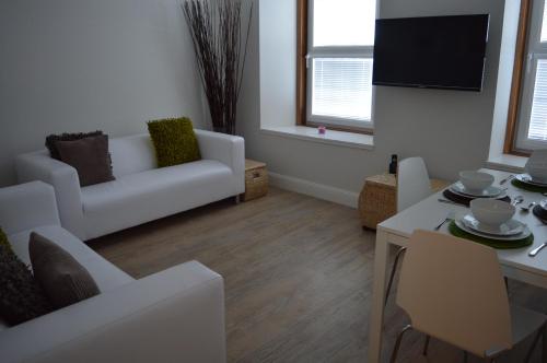 uma sala de estar com um sofá branco e uma mesa em No.34 Apartment em Perth
