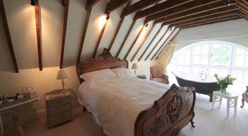 1 dormitorio con 1 cama grande y bañera en Cherry Orchard Farm, en Bath