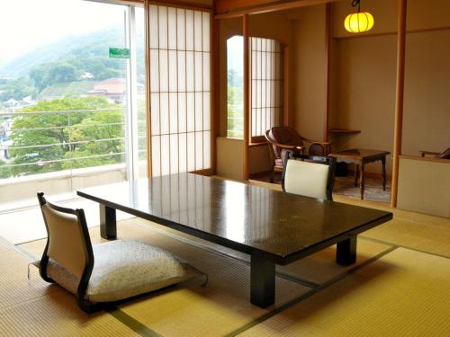 a table and chairs in a room with a large window at Zazan minakami in Minakami