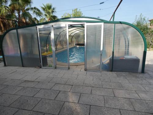 une maison en verre avec une piscine. dans l'établissement Lotus, à Cébazan