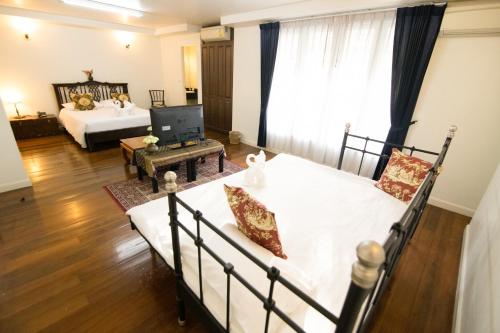 a bedroom with a bed and a television in it at SSIP Boutique Dhevej Bangkok in Bangkok