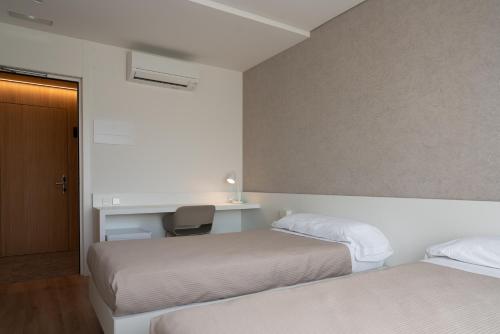 a hotel room with two beds and a desk at Hotel Las Terrazas in Burgos