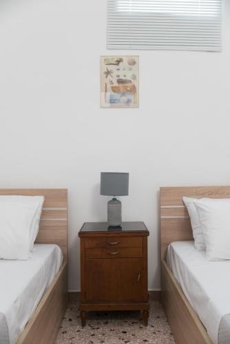 a bedroom with two beds and a table with a lamp at Chez Georges in Parikia