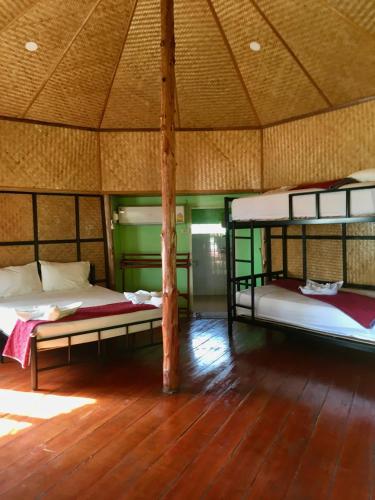 a room with two bunk beds and a wooden floor at TP Hut Bungalows in Ko Chang