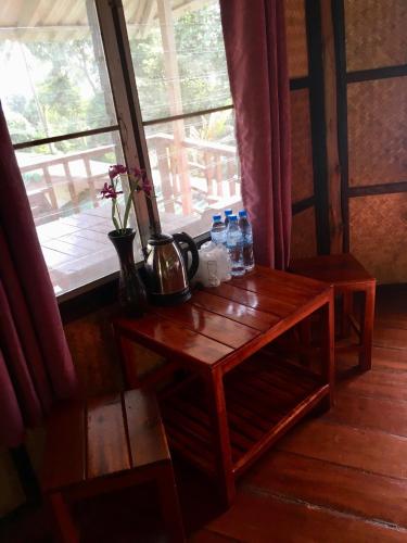 a table with water bottles on it next to a window at TP Hut Bungalows in Ko Chang