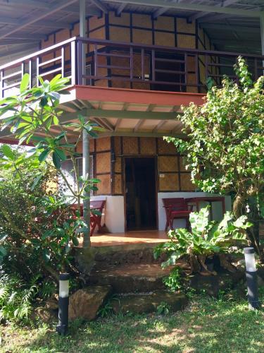 a house with a porch and a balcony at TP Hut Bungalows in Ko Chang