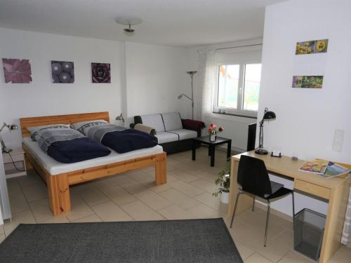 a bedroom with a bed and a desk in it at Ferienwohnung Rheingeschaut in Bad Bellingen